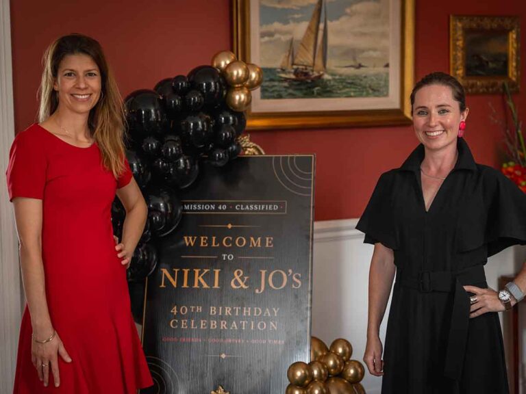 Two hosts beside a welcome sign at a 40th birthday celebration in Dublin
