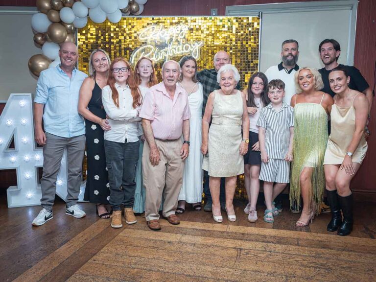 Extended family group photo beside a light-up 40 sign at a birthday party in Dublin