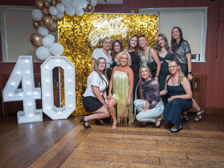 Friends posing by a gold sequin wall and light-up 40 sign at a 40th birthday party in Dublin