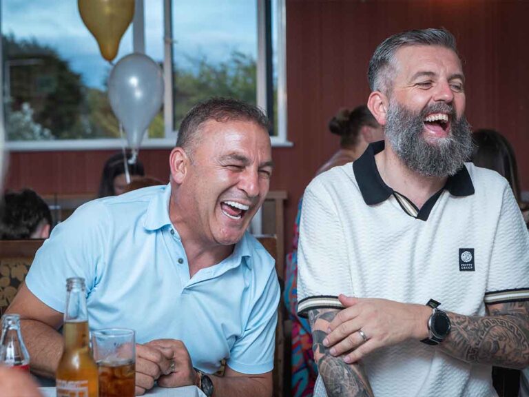 Two guests laughing together at a birthday celebration in Dublin