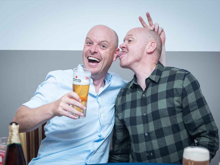 Friends joking and raising a pint at a private party in Dublin